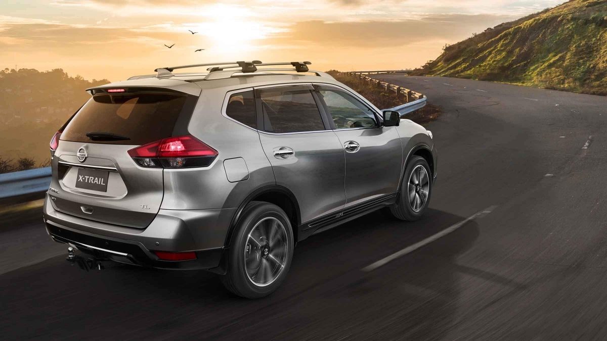 Nissan X-TRAIL driving on road towards sunset