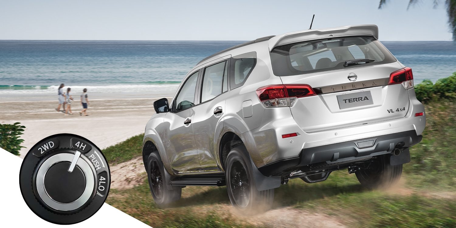 Nissan Terra driving on a dirt towards beach with 4x4 dial inset