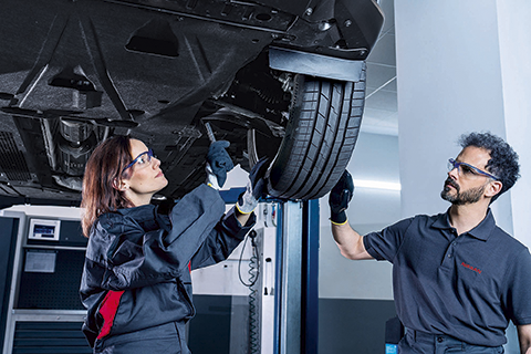 A women and a man repairing a car