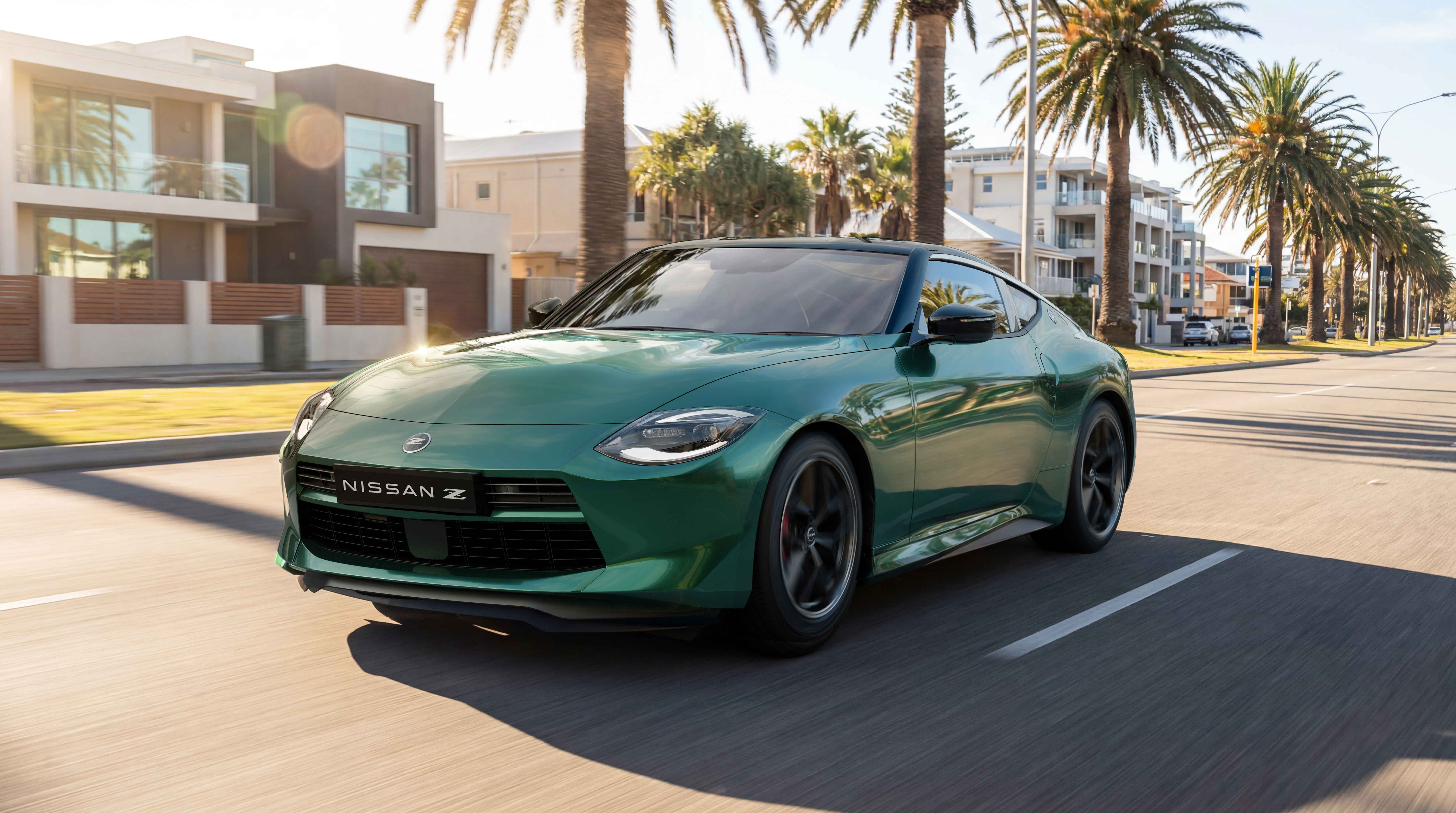 Green Nissan Z sports coupe driving along a palm-lined coastal street past modern beachside homes