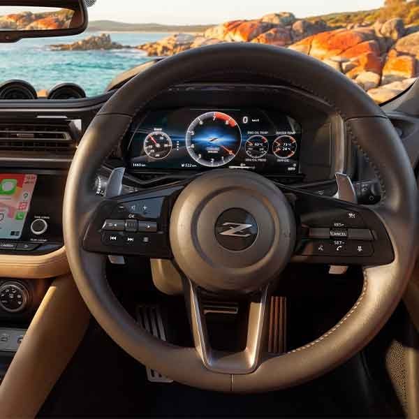 Close-up of steering wheel and infotainment system in Nissan Z Coupe with Tan Interior