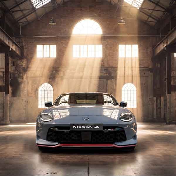 Front end view of a Nissan Z Nismo parked in a sunlit industrial building