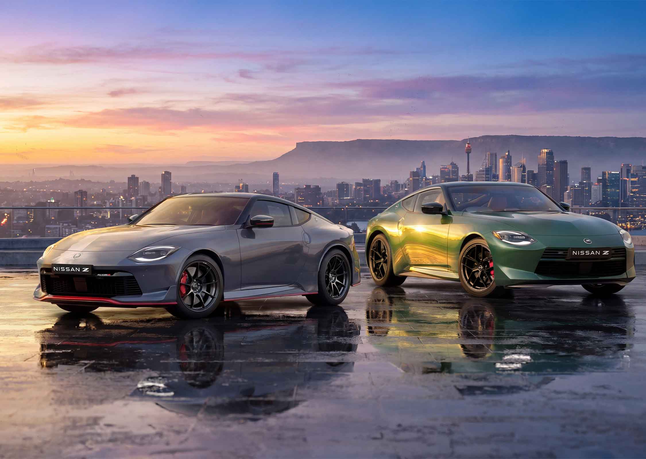 Nissan Z Coupe and Nismo parked on a rooftop overlooking a city skyline at sunset