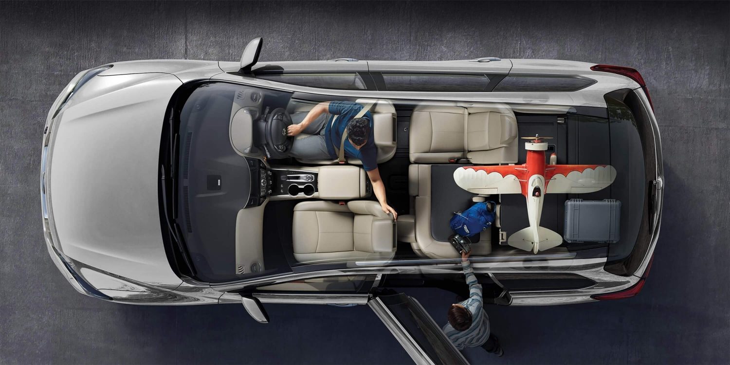 Father and son packing a large R/C plane into boot of a Nissan Pathfinder