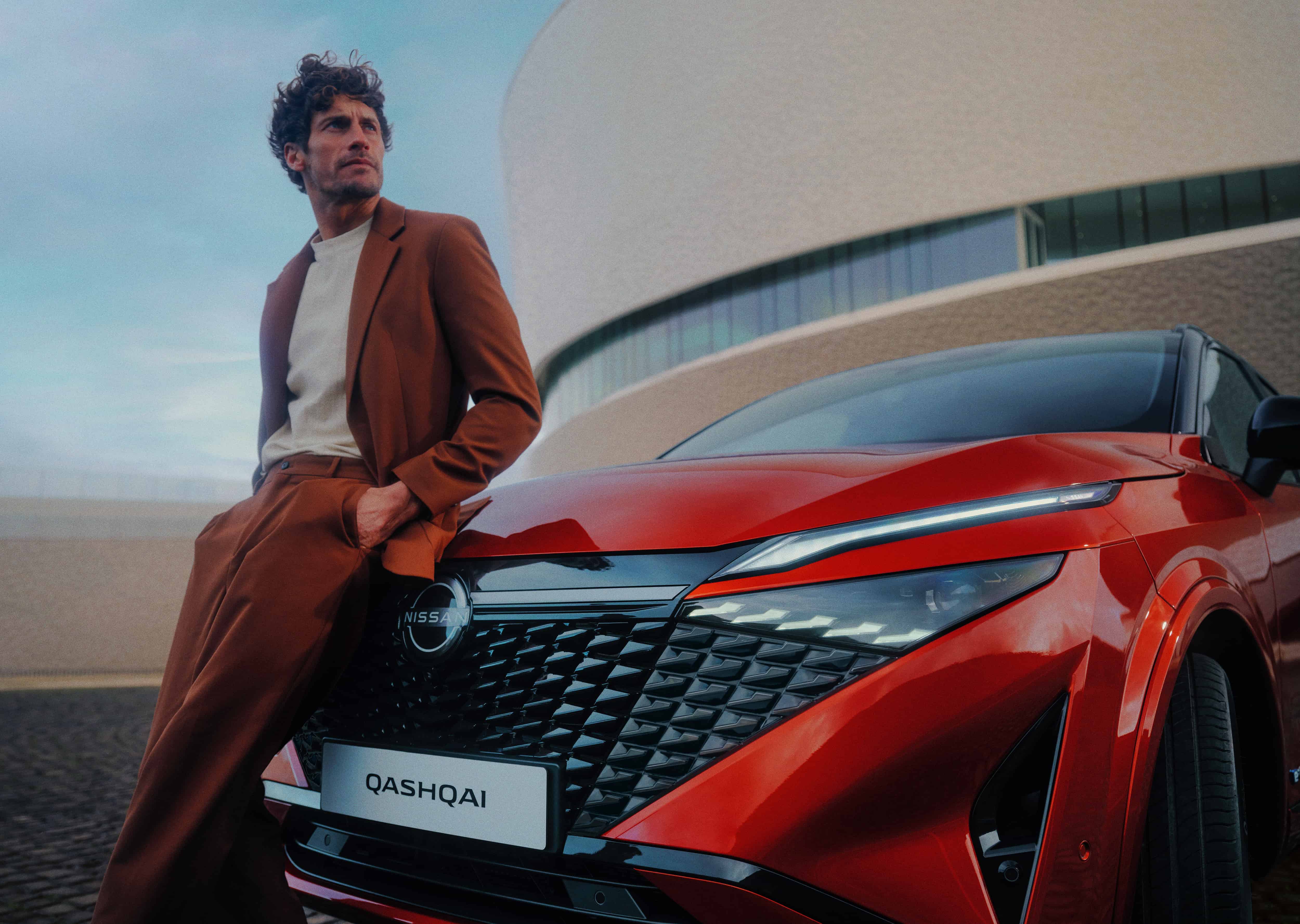Nissan Qashqai e-Power full front static view with man leaning against the bonnet.